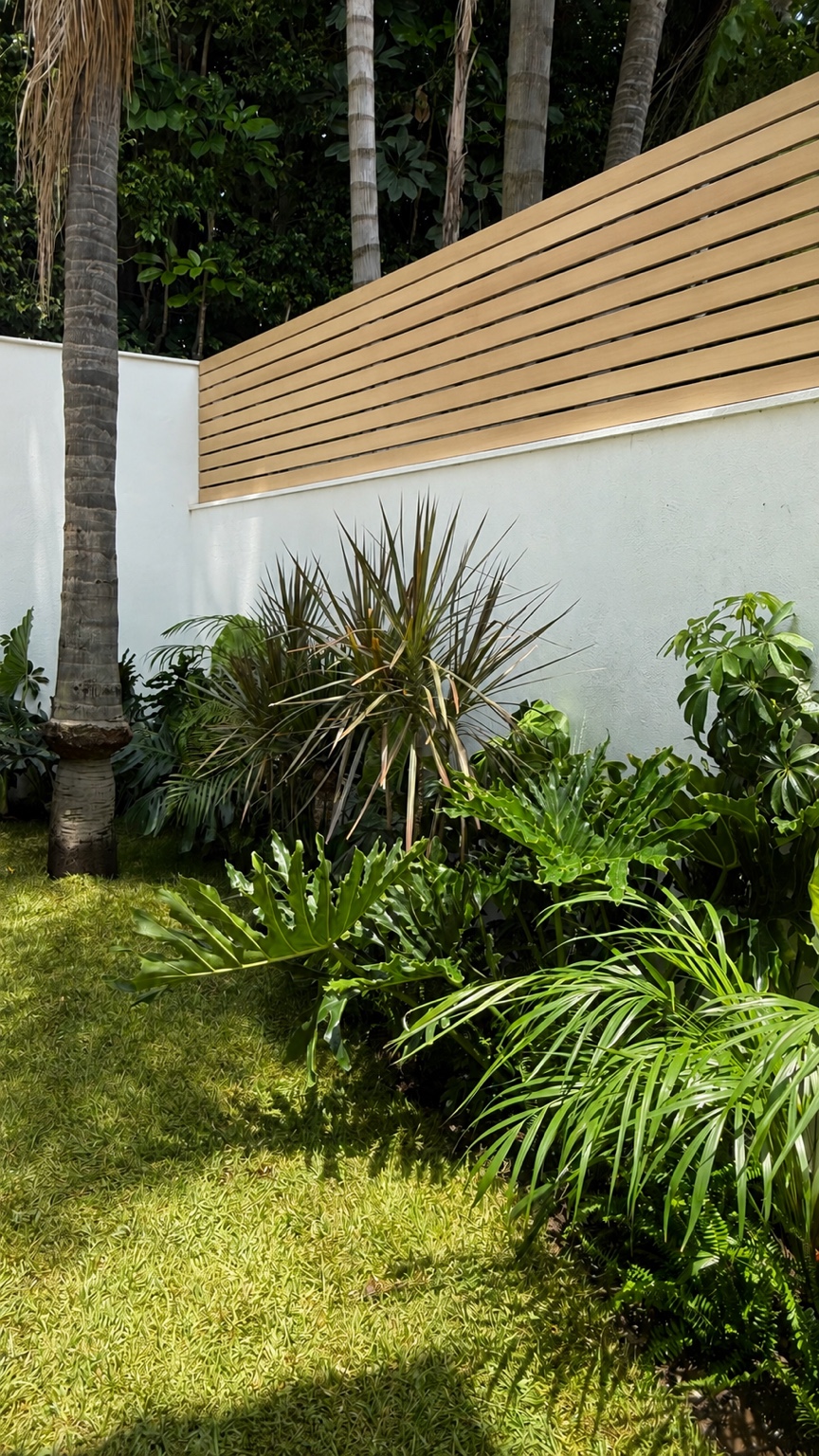 Jardín tropical junto a un muro blanco y celosía de madera